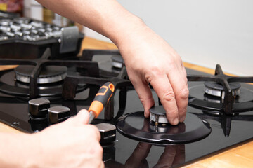 Gas stove repair. Service warranty repair of household appliances. A man repairs a gas stove at...