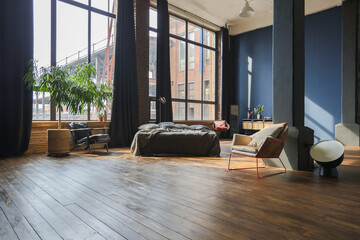 dark interior of a modern stylish huge open-plan loft-style studio apartment with columns and high...