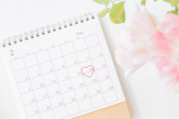 Valentines day composition with calendar page and pink tulips in a vase on a light background
