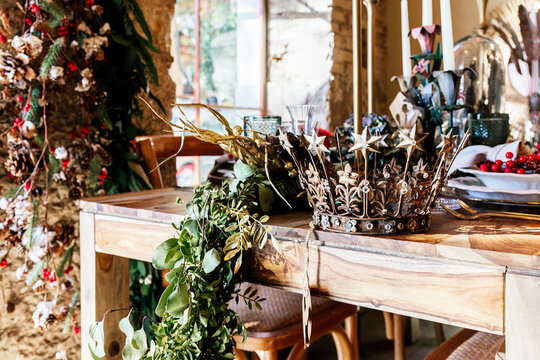 Decorative vintage crown and leafs on wooden table in decor shop during Christmas season
