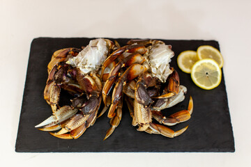 Raw, cleaned, uncooked Dungeness crab legs sit on a platter in the kitchen ready to be cooked for dinner