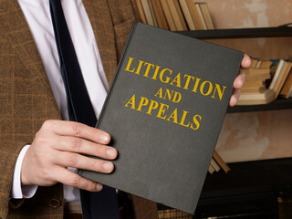 Hands with litigation and appeals rules book.