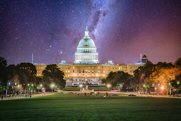 The US Capitol building in Washington D.C. on the National Mall at night with milkyway and stars in the sky.