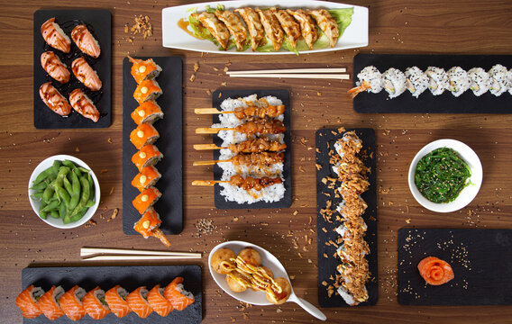 Top view of assorted sushi and rolls arranged on wooden table in restaurant with Asian food