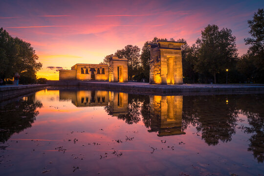Amazing view of Temple of Debod located near pond in Madrid at sundown