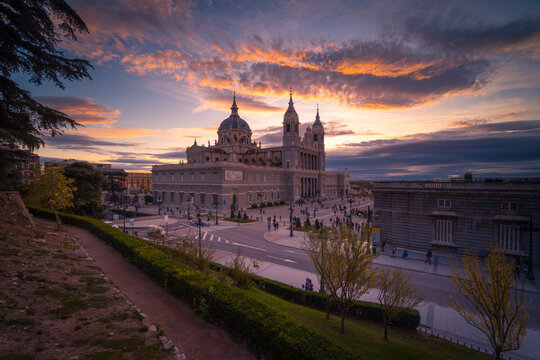Majestic view of Almudena Cathedral on background of orange sundown sky in Madrid