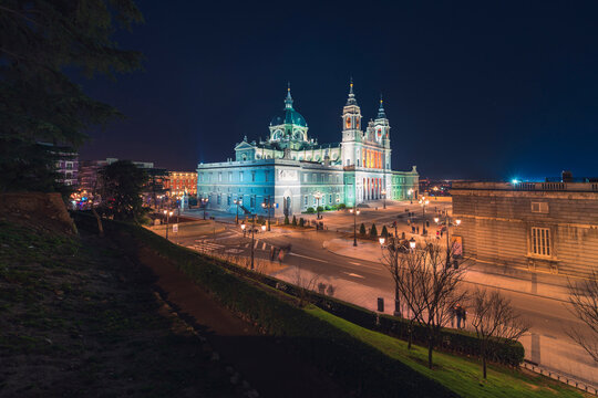 Majestic view of Almudena Cathedral with illuminated exterior on background at night in Madrid