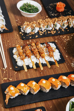 Top view of assorted sushi and rolls arranged on wooden table in restaurant with Asian food