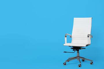 Comfortable office chair on light blue background, space for text