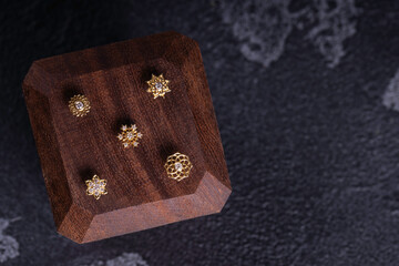 Beautiful piercing jewelry on wooden display. Macro shot. Selective focus.