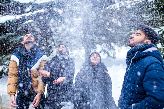 group of four indian having fun playing in snow outdoors spending Chrisymas holidays