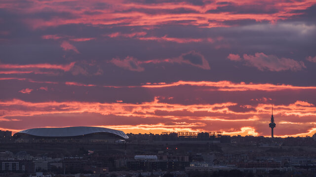 Spectacular view of Wanda Metropolitano Stadium with curved roof on background of orange sundown sky in Madrid