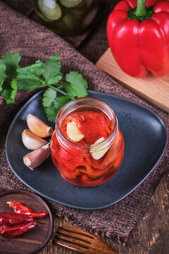 Vegan baked red peppers with garlic in crystal jar.