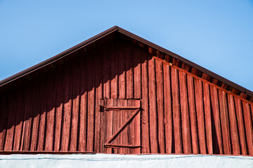Fototapeta premium The attic of a red wooden house with a closed door.
