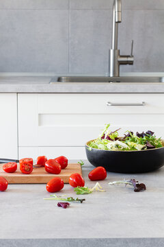 Salad green leaves in bowl placed in table with fresh tomatoes