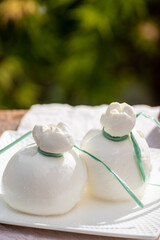 Fresh italian soft cheese burrata or burratina served on outdoor terrace in sunny day