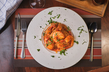 Beautiful dish of spaghetti  with prawns on wooden table.