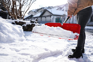 Person shoveling snow outdoors on winter day, closeup