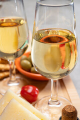 Glasses of dry fino sherry wine served with spanish tapas, manchego cheese, green olives, cheese crackers
