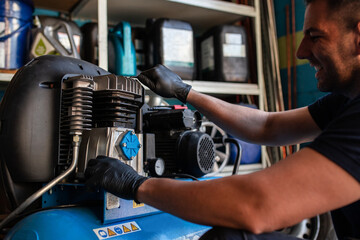 Side view of professional mechanic in protective gloves inspecting engine while working in repair service workshop
