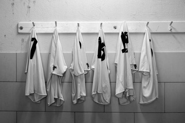 Six football shirts hanging on dressing room before/after the game - black and white