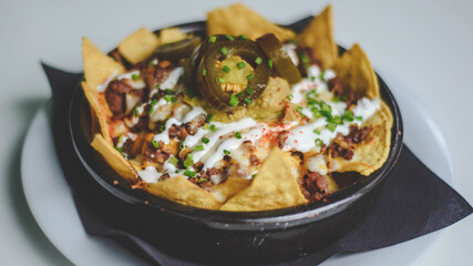 Racion de nachos picantes con carne y queso tipicos mexicanos.