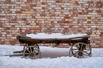 an ancient wooden cart on the background of an ancient brick wal