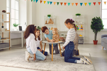 Children playing with educational toys in cozy after-school centre. Group of quiet diverse...