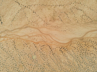 Top down view: small stream of water at the bottom of a dry lake. The unearthly landscape of the...