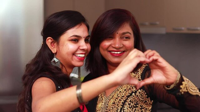 Valentine's Day concept indian women make with fingers heart shape smile look at camera through symbol