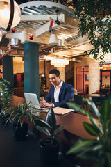 Smiling businessman checking his email in a cafe