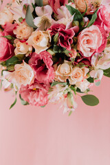 Bouquet with pink anemones and roses and eucalyptus branches in round pink box. On pink background. Present, spring time, happy women's day. Top view.