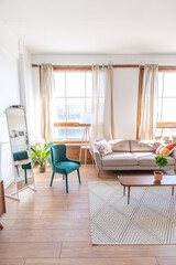 Vintage studio apartment interior in light colors in old style. huge room with large windows with a living room area and a bedroom area. direct sunlight inside.