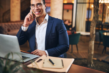 Attractive joyous businessman calling on his cellphone