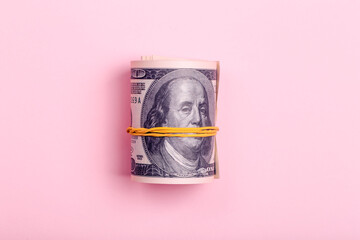 Bundle of one hundred dollar money on a pink minimal background. Cash bribe, earnings and profit...