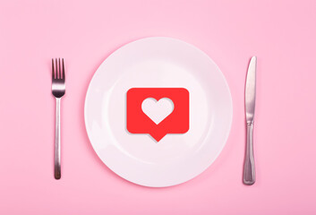 Heart on an empty plate on a pink background. Minimal art creative concept. Red heart as a symbol of love, romance and 