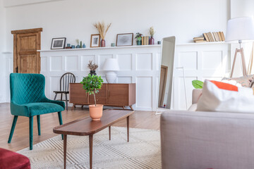 Vintage studio apartment interior in light colors in old style. huge room with large windows with a living room area and a bedroom area. direct sunlight inside.