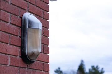 A light bulb mounted on a brick column.