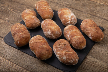 freshly baked  handmade ciabatta breads on black slate, 