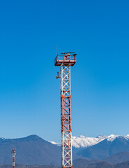 Sochi, Russia - December 08, 2020: Border with Abkhazia from Russian side. High tower with radar in background of Caucasus mountains with snowy peaks. Clear sunny day. Border is locked tight.