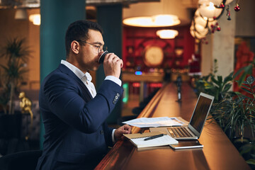 Male in eyeglasses taking a sip of coffee