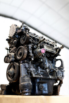 Low angle of dirty car engine placed on table in bright facility of car service