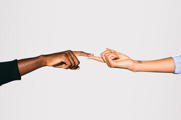 Close-up of a black man' touching white woman's finger over white background