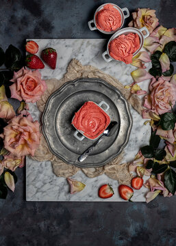 Top view composition with delicious homemade strawberry sorbet served on table with fresh berries and rose flowers