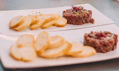 Steak Tartar con tostatadas sobre un plato blanco