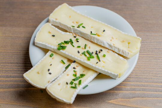 Brie cheese slices on white plate