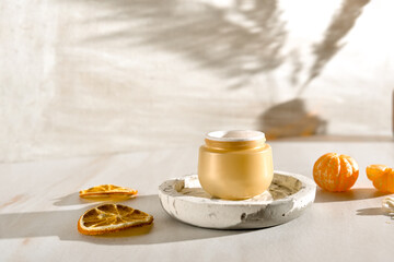 Beauty lifestyle background with Opened Jar of face cream and fresh tangerines.  winter skin care concept