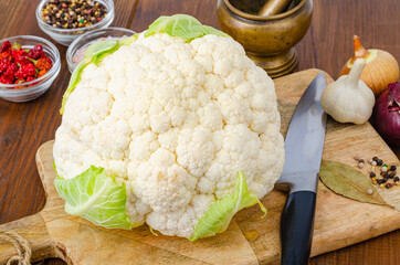 Head of cabbage fresh organic cauliflower on wooden background, spices. Studio Photo