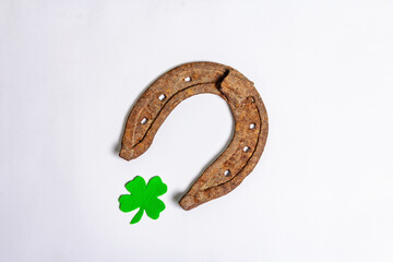 Badly worn horseshoes with a felt clover leaf isolated on white background