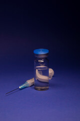 Vaccine bottle phial with no label, medical syringe injection needle. isolated on blue background....